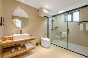a bathroom with a sink toilet and a mirror at Xizhou Feng Shangju in Dali +55 photos