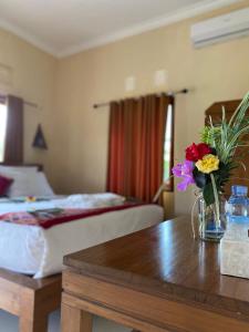 a hotel room with a table with a vase of flowers on it at Yoga Homestay in Munduk