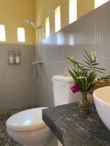 a bathroom with a toilet and a sink and a plant at Yoga Homestay in Munduk +14 photos