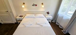 a bedroom with a large white bed with two tables at Villa Loebel 1881 in Juodkrantė