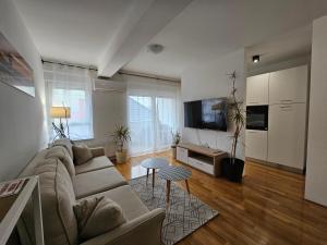 a living room with a couch and a tv at OnPoint Apartmani in Osijek