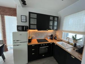 a kitchen with a white refrigerator and a sink at Norda Loft in Dębki +46 photos