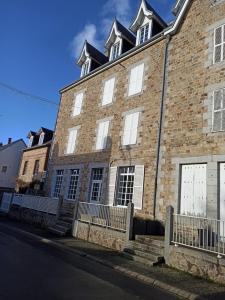 a large brick building with white doors and windows at Appartement 2 à 4 personnes proche de la mer in Saint-Jean-le-Thomas