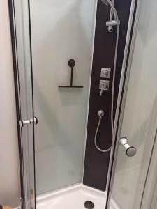 a shower with a glass door next to a sink at Appartement 2 à 4 personnes proche de la mer in Saint-Jean-le-Thomas