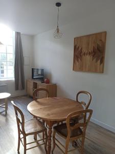 a dining room with a wooden table and chairs at Appartement 2 à 4 personnes proche de la mer in Saint-Jean-le-Thomas +2 photos