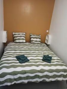 a bed with two towels sitting on top of it at Appartement 2 à 4 personnes proche de la mer in Saint-Jean-le-Thomas