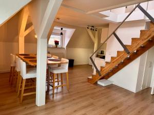 a kitchen and dining room with a wooden table and stairs at Dat Höhnerstübche Apartment in Siegen