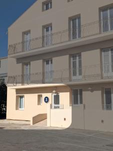 a large white building with a balcony on the side at Hôtel Flor in Saint-Florent