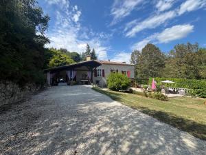 a driveway leading to a house with a pavilion at Charmante maison avec piscine en pleine campagne in Bajamont