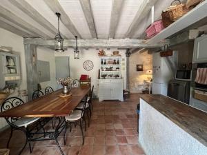 a kitchen with a table and chairs in a room at Charmante maison avec piscine en pleine campagne in Bajamont