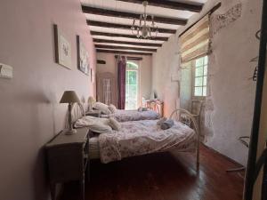 a bedroom with a bed and a table and a window at Charmante maison avec piscine en pleine campagne in Bajamont +7 photos