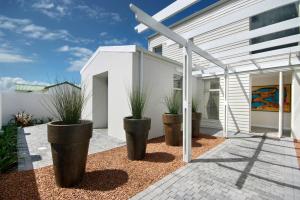 a group of potted plants in front of a building at Spatalla Holiday Homes in Kleinmond