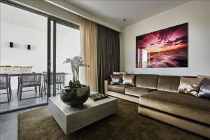a living room with a couch and a table at The Pearl of Jan Thiel villa with private pool gym and game room in Willemstad