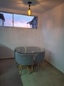 a table and chairs in a room with a window at Hermosa casa con espacios independientes cerca a Mall plaza in Manizales