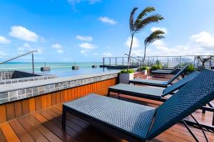 a balcony with chairs and a view of the ocean at Flats pé na areia Alta Garden in João Pessoa