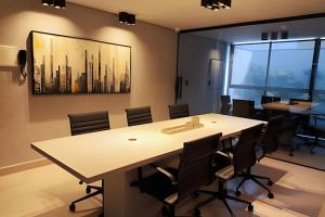 a meeting room with a large table and chairs at Flats pé na areia Alta Garden in João Pessoa