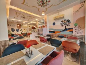 a restaurant with tables and chairs in a room at Hotel Omni Plaza in Jodhpur
