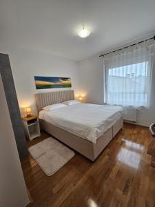 a bedroom with a large bed and a window at OnPoint Apartmani in Osijek