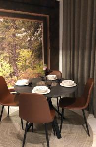 a black table with chairs and plates and a window at Premium City Center 2 rooms Apartment Glassed Balcony FREE PRIVATE PARKING in Kemi