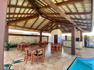 a patio with a table and chairs and a pool at Flecheiras Duplex com 3 suítes e piscina in Trairi