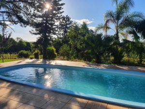 una piscina in un cortile alberato di Pousada Menezes a São Gabriel Altre 7 foto
