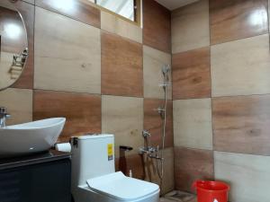 Un baño con inodoro, lavabo y ducha. en CLOUDSCAPE HOMESTAY, en Pīrmed