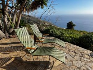 2 chaises vertes assises sur un chemin en pierre près de l'océan dans l'établissement Casa Barbara, à Puntagorda 10 autres photos