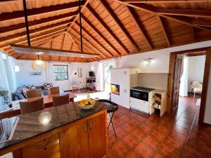 une cuisine et un salon avec des plafonds en bois et une table dans l'établissement Casa Barbara, à Puntagorda