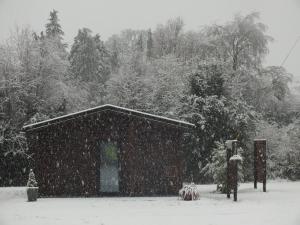 a small building in the snow with trees in the background at KILLARNEYCABINSie Stunning & Spacious Scandanavian Timber Lodges in Killarney
