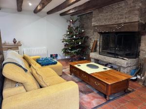 a living room with a couch and a christmas tree at Les Bâtisses de 1872 in Ménéac