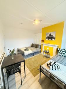 a living room with two beds and a table at Finsbury Park Rooms in London +34 photos