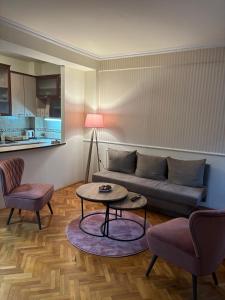 a living room with a couch and a table and chairs at Lovely square apartment Purple Velvet 43 Macedonia Stree in Skopje