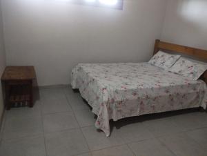 ein kleines Schlafzimmer mit einem Bett und einem Tisch in der Unterkunft casa do conde in Luis Correia