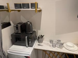 encimera con cafetera sobre un microondas en Luxury Studio in Victoria, 7 minutes walk to Victoria Station, Room 2, en Londres 7 fotos más
