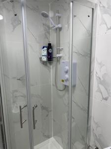 Un baño con ducha con puerta de cristal en Luxury Studio in Victoria, 7 minutes walk to Victoria Station, Room 2, en Londres