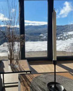 a candle sitting on a table in front of a window at Tornik view villa Zlatibor 2 in Ribnica