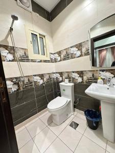 a bathroom with a toilet and a sink at In Apartments in Jeddah +30 photos