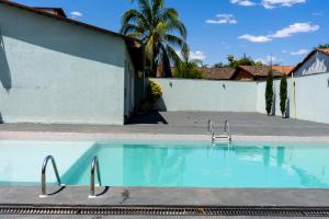 a swimming pool in front of a white building at Pousada Casa Flor-Aurora -TO in Manhã
