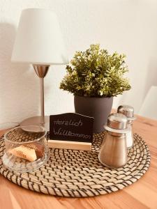 ein Tisch mit einem Korb mit einer Kerze und einer Lampe in der Unterkunft Nähe Mainz - Ferienwohnung - Apartment Breivogel in Wörrstadt in Wörrstadt