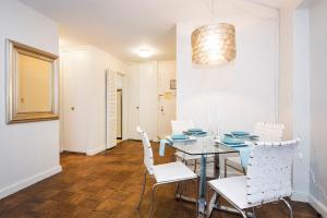 comedor con mesa y sillas blancas en Murray Hill East Suites en Nueva York
