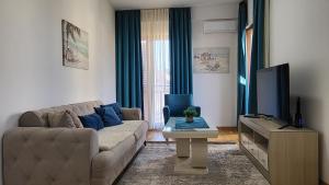 a living room with a couch and a tv at NY Apartment, two bedrooms in Tivat