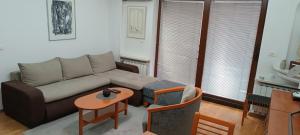 a living room with a couch and a table at Lovely square apartment Purple Velvet 43 Macedonia Stree in Skopje +16 photos