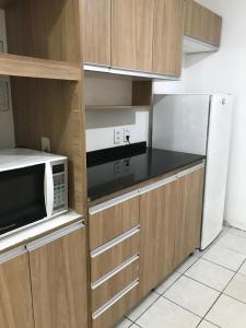 a kitchen with a microwave and a refrigerator at Linhares hospedagem in João Pessoa
