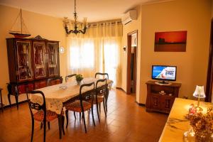 a dining room with a table and chairs and a television at La perla sul Tirreno in Briatico