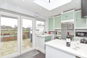a kitchen with green and white cabinets and a window at Dove Cottage is a Central, Riverside, Charming Victorian Cottage in Arundel