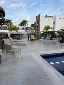 a patio with chairs and a pool on a building at CONDO Marena 2 in Playa del Carmen