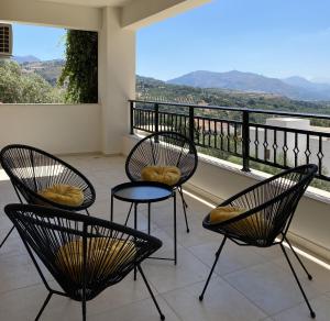 two chairs and a table on a balcony with a view at Mons Apartments in Spílion