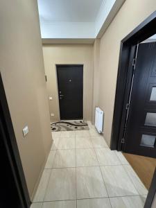 a hallway with a black door and a tile floor at Harmony apartment in Chişinău