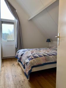 a bedroom with a bed and a window at Mijn kleine vakantiehuis in Breskens in Breskens
