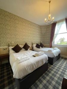 a hotel room with two beds and a chandelier at Headlands Hotel in Llandudno